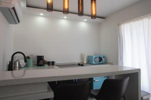 a kitchen with a counter with chairs and a microwave at La Ceiba Suite 2 with private plunge pool in Anasco