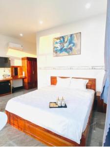 a bedroom with a large white bed with two candles on it at Moonlight House in Cu Lao Thu