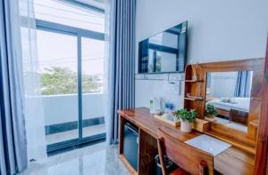 a bathroom with a desk and a mirror and a sink at Moonlight House in Cu Lao Thu