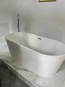 a white bath tub sitting on a counter in a bathroom at Willow Lodge in Kilham