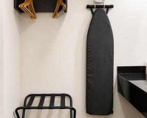 a black tie hanging on a wall next to a chair at Studio 6 Suites Mesquite, TX – Gross Rd. in Mesquite