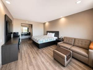 a hotel room with a bed and a couch at Studio 6 Suites Mesquite, TX – Gross Rd. in Mesquite