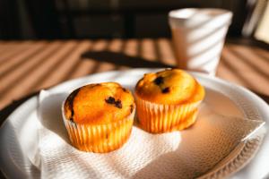 two muffins on a white plate on a table at Rodeway Inn Monroe in Monroe