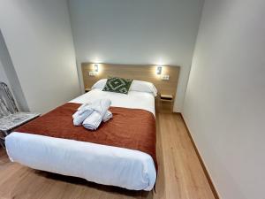 a bedroom with a large bed with towels on it at Apartamentos Los 5 Sentidos in Grado