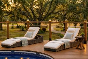 two lounge chairs on a deck next to a pool at Serene Mountain Retreat With Pool in Clermont +35 photos