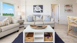a living room with a couch and a table at Sunrise Oasis - Top Floor Ocean Pointe 2411 in Key Largo