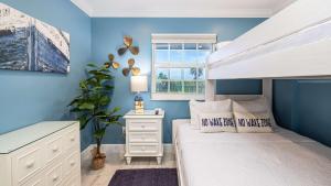 a bedroom with a white bed and a blue wall at Sunrise Oasis - Top Floor Ocean Pointe 2411 in Key Largo