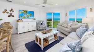 a living room with a couch and a table at Sunrise Oasis - Top Floor Ocean Pointe 2411 in Key Largo