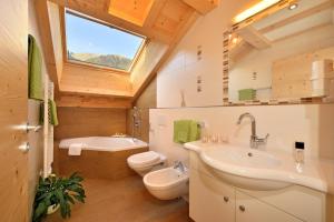 a bathroom with a sink and a toilet and a window at Feldererhof GsiesApt Dolomitenblick in Valle Di Casies +28 photos
