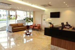 a lobby with a reception desk and a couch at Easy Hotel Cachoeiro de Itapemirim by Atlantica in Cachoeiro de Itapemirim