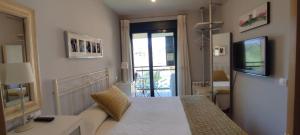 a bedroom with a bed and a television in a room at Costa de Llanes in Posada de Llanes