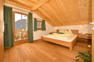 a bedroom with a bed and a large window at Feldererhof GsiesApt Dolomitenblick in Valle Di Casies