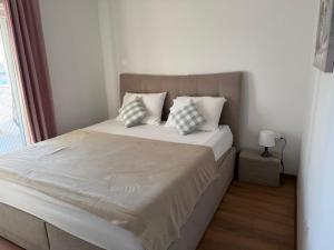 a bedroom with a bed with pillows and a window at Muring Apartments in Tribunj