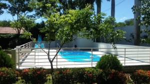a swimming pool with a white fence around it at Pousada Jubaia in Bonito