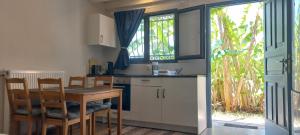 a kitchen with a table and chairs and a window at Corfu Green Escape in Achílleion