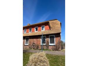 an old brick house with hay in front of it at Opas Hus auf Pellworm in Pellworm +9 photos