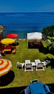 a group of chairs and umbrellas on a field with the ocean at Seafront Apartment Rize - Ardeşen in Ardeşen +9 photos