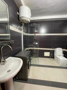 a bathroom with a sink and a toilet at You Royal in Dakar