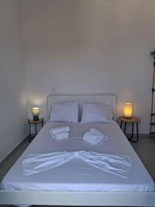 a white bed with two towels on top of it at Thea Nisaki Mochlos in Mochlos