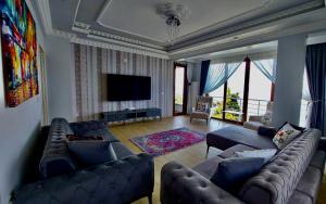 a living room with couches and a flat screen tv at Seafront Apartment Rize - Ardeşen in Ardeşen