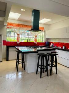a kitchen with a island with stools in it at La finca de dulce in Silvania