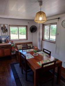 a dining room with a wooden table and chairs at Le coin des Maripas in Quesnel