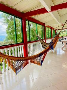 a hammock in a room with windows at La finca de dulce in Silvania