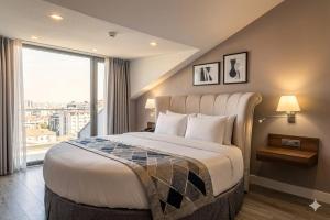 a bedroom with a large bed with a large window at Adana Plaza Hotel in Adana +19 photos