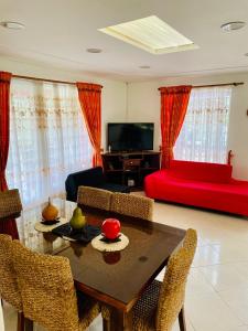a living room with a table and a red couch at La finca de dulce in Silvania