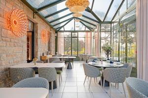 ein Restaurant mit Tischen und Stühlen und Glasdecken in der Unterkunft La Ramade - Teritoria in Avranches