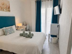 ein Schlafzimmer mit einem Bett, auf dem ein Teddybär liegt in der Unterkunft Hostal Nerjasol in Nerja