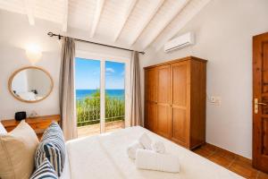 a bedroom with a bed with a view of the ocean at Villa Gardenia in Vlachopoulátika +14 photos