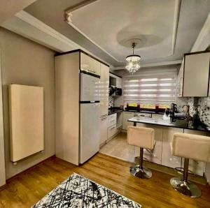 a kitchen with a refrigerator and two chairs in it at Seafront Apartment Rize - Ardeşen in Ardeşen