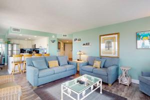a living room with two blue couches and a table at #1131 The Mermaid Pad in Gulf Highlands +27 photos