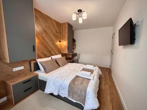 a bedroom with a bed and a flat screen tv at Arena Apartment in Gotse Delchev