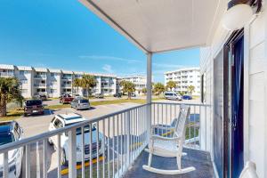 a balcony with a chair and a view of a parking lot at Plantation East #1110 in Gulf Shores