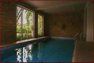 a bathroom with a swimming pool with a window at Bridge Apartment Lagos in Lekki