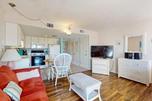 a living room with a red couch and a kitchen at Plantation West #1261 in Gulf Highlands