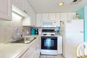 a kitchen with a sink and a white refrigerator at Plantation West #1261 in Gulf Highlands