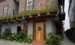 a house with a wooden door and ivy on it at Bridge Apartment Lagos in Lekki