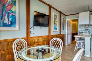 a dining room with a table and chairs and a television at Plantation East #1201 in Gulf Highlands +61 photos