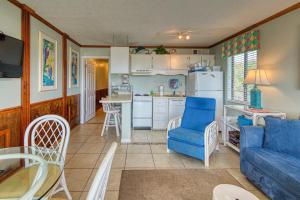 a living room with a blue couch and a kitchen at Plantation East #1201 in Gulf Highlands