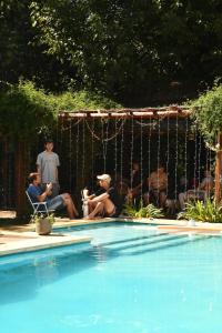 a group of people sitting around a swimming pool at Rincón de Rodríguez in General Rodríguez
