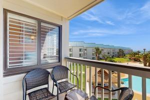 a balcony with two chairs and a view of the ocean at Plantation West #1365 in Fort Morgan
