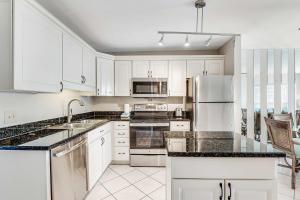 a white kitchen with white cabinets and appliances at Condo by the beach with Gulf views plus shared pool in Fort Morgan