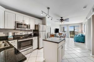 a kitchen with white cabinets and appliances and a living room at Condo by the beach with Gulf views plus shared pool in Fort Morgan +45 photos