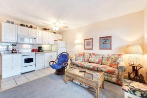 a living room with a couch and a kitchen at Waterfront Gulf condo with beach access shared pool in Fort Morgan