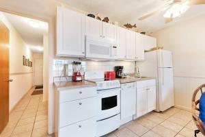 a kitchen with white cabinets and white appliances at Waterfront Gulf condo with beach access shared pool in Fort Morgan