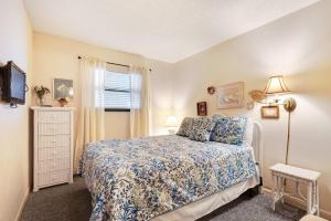 a small bedroom with a bed and a window at Waterfront Gulf condo with beach access shared pool in Fort Morgan