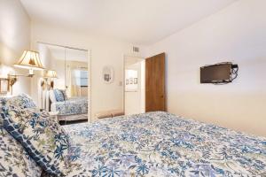 a hotel room with a bed and a tv at Waterfront Gulf condo with beach access shared pool in Fort Morgan +37 photos
